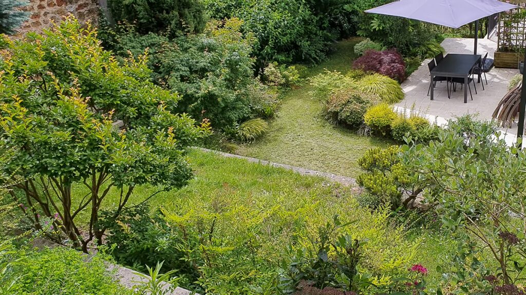 Vue plongeante sur le jardin avec terrasse, pelouse et massifs à Fontenay-aux-Roses (92)